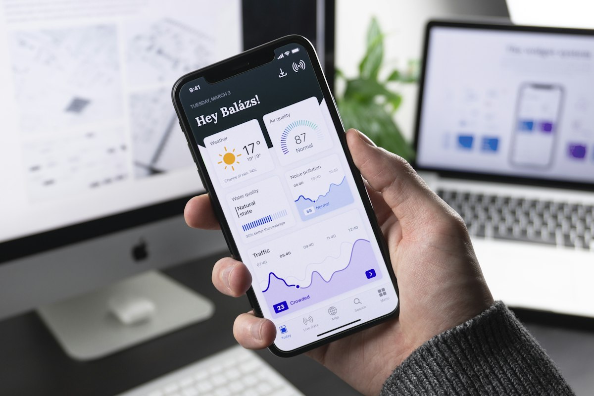 Utente che usa un'app mobile con grafici e dashboard