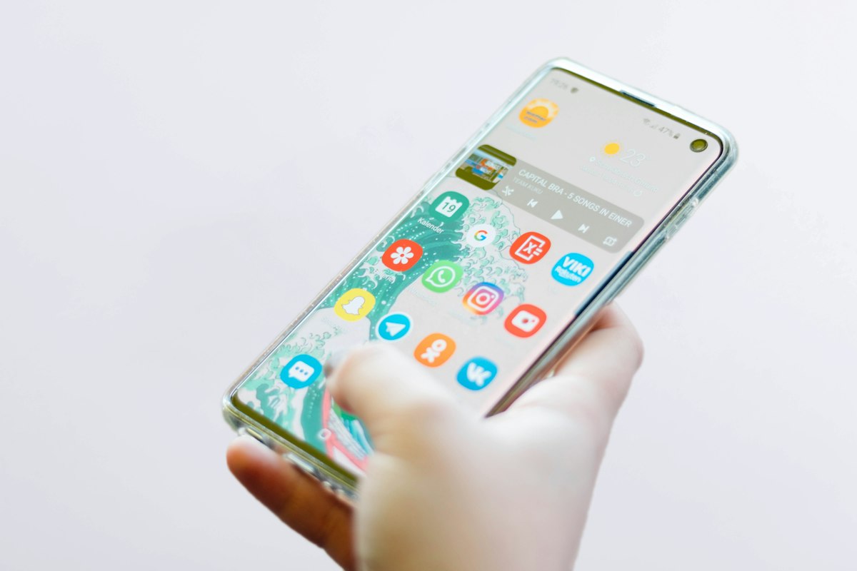 Mano che tiene uno smartphone con icone di app colorate